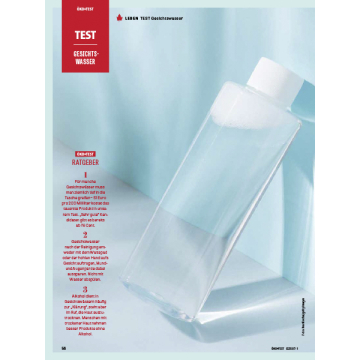 Das Bild zeigt eine durchsichtige Flasche Gesichtwasser vor einer hellblauen Wand