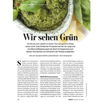 Textseite mit Überschrift 'Wir sehen Grün' und Artikel über grünes Pesto, inklusive ÖKO-TEST Logo und Testhinweise. Hintergrund verschwommene Abbildung von Basilikum