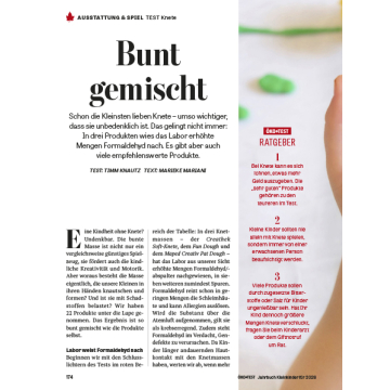 Zwei offene Kinderhände halten eine rote Knetfigur in Herzform mit gelben und blauen Augen und einem gelben Mund.