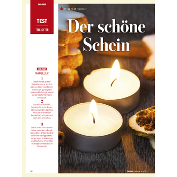 Zwei brennende Teelichter in runden Metallbehältern auf dunklem Holztisch, daneben getrocknete Orangenscheiben.