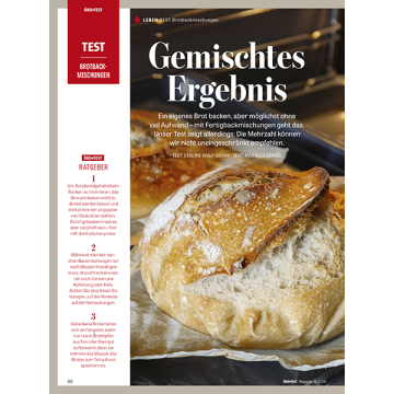 Nahaufnahme eines angeschnittenen, goldbraun gebackenen Brotes mit knuspriger Kruste auf dunklem Untergrund.